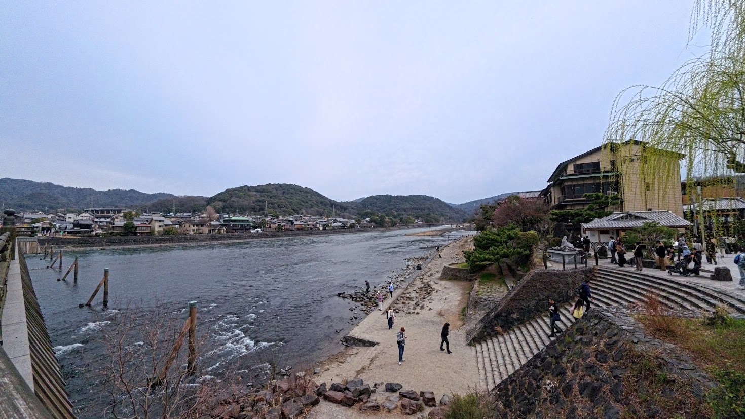 People walking beside the river and mountains in Arashiyama