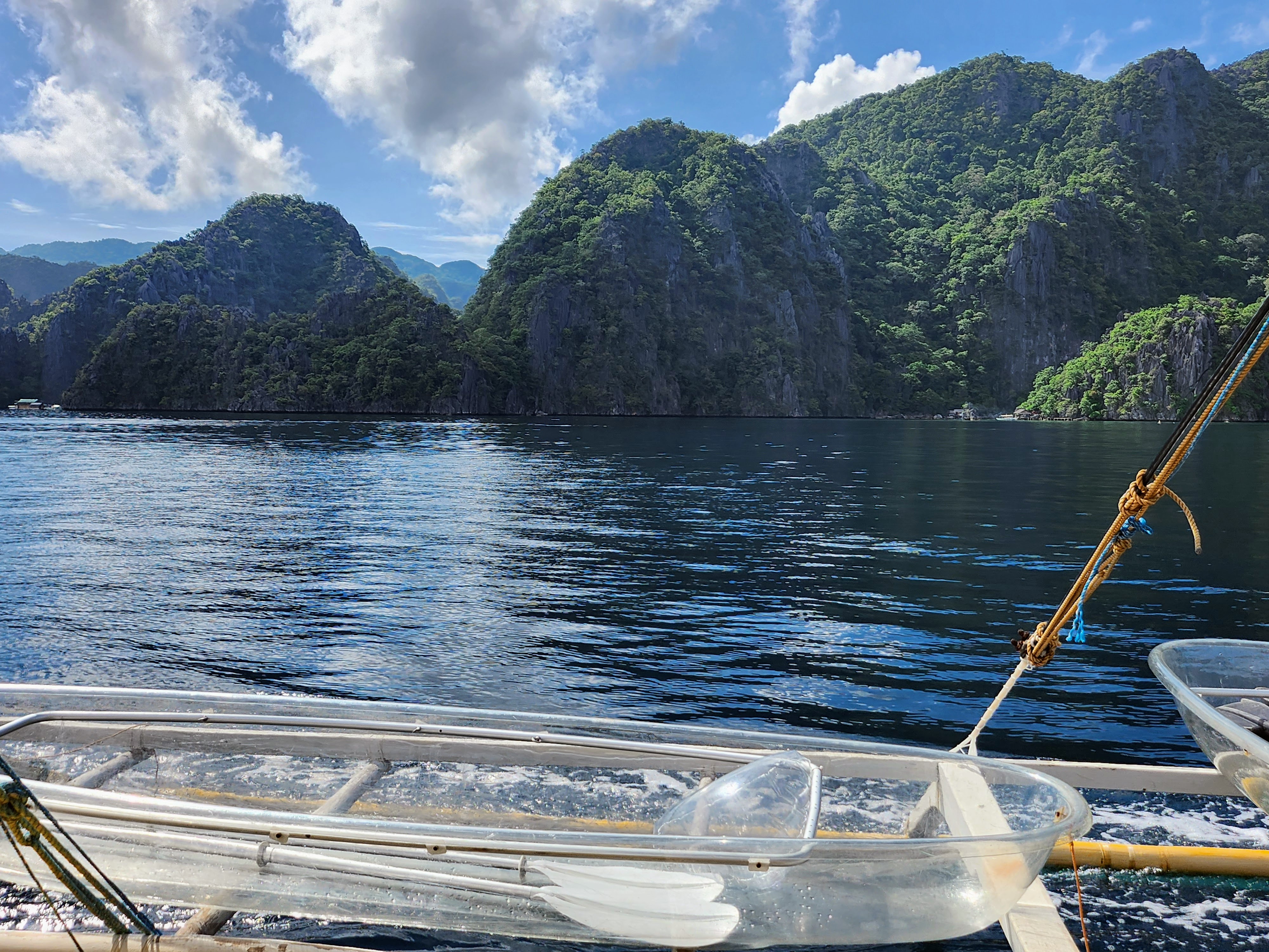 Clear kayaks on blue water beneath limestone cliffs in Coron, Palawan