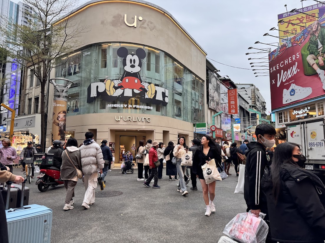 Shoppers crossing a busy street in Ximending