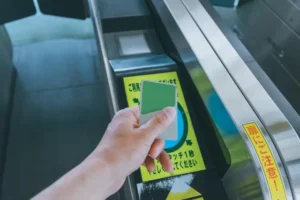 Traveler tapping a Suica card at a Tokyo train station ticket gate