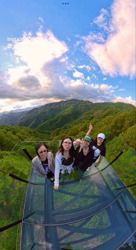 Group of family standing on a glass deck overlooking the mountains in Baguio.