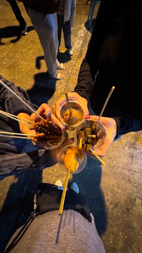 Assorted street food served in cups and skewers enjoyed during a night market visit in Baguio.