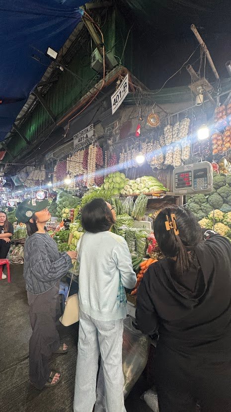 Visitors browsing fresh vegetables inside Baguio Public Market.