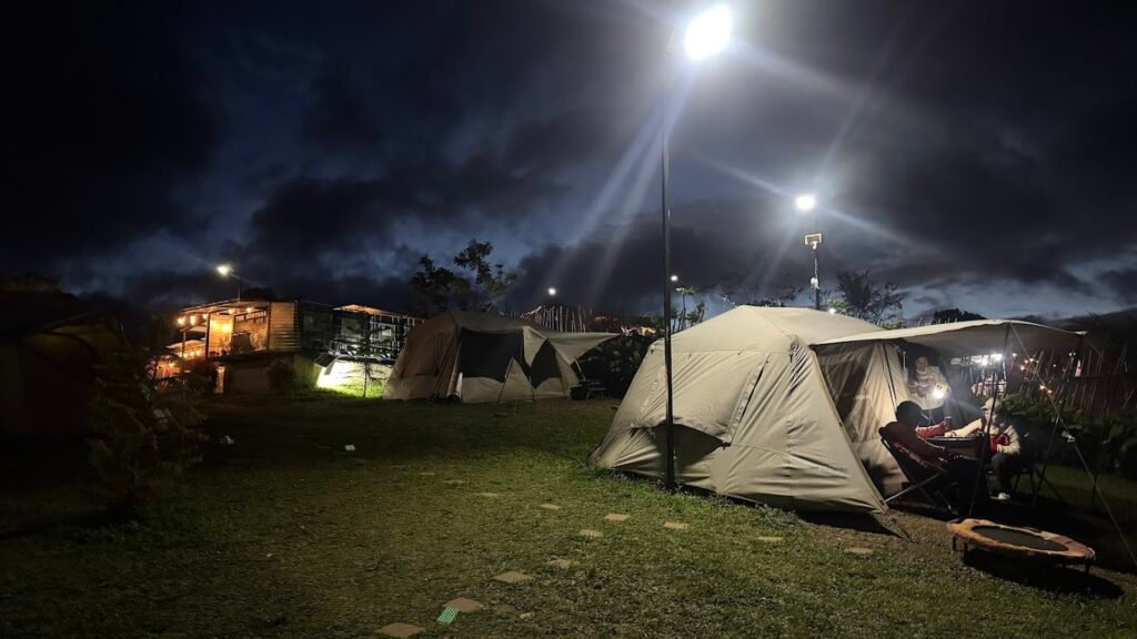 Illuminated camping tents under the night sky.