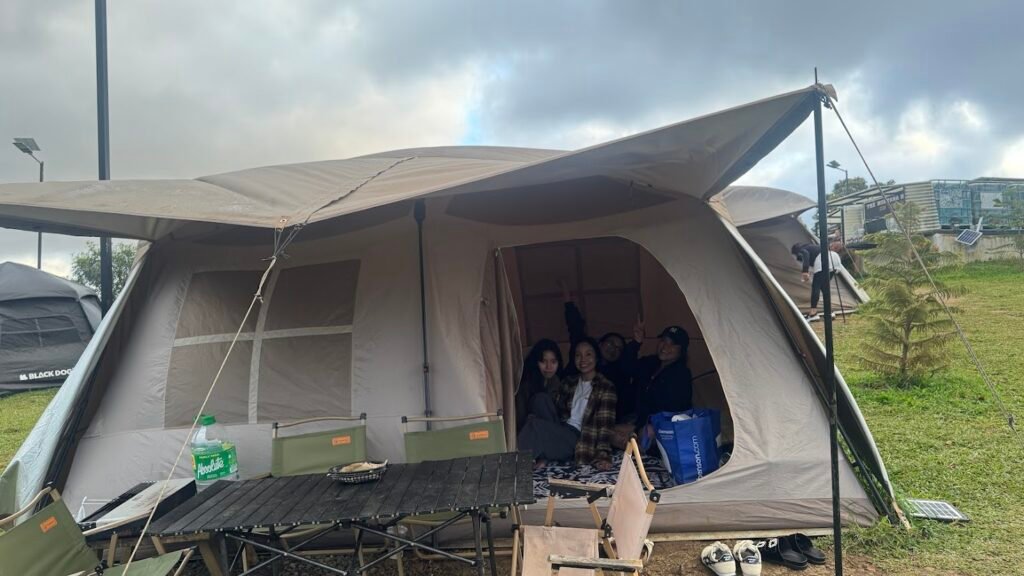 Family members sitting inside a spacious camping tent.