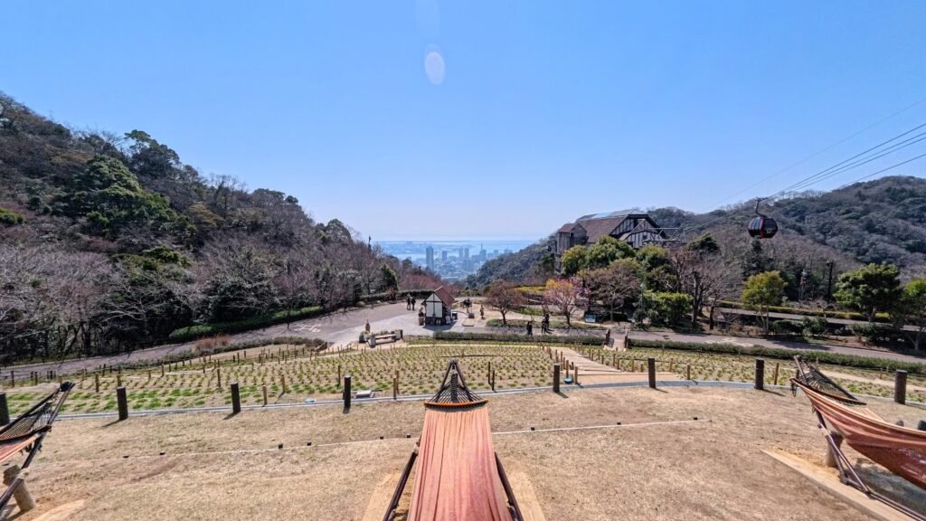 Hammocks overlooking Kobe Nunobiki Herb Gardens with mountain and city views in the background.