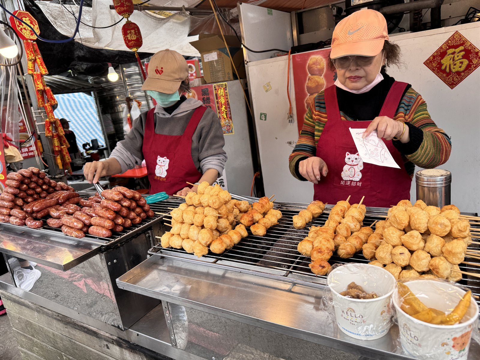 Food vendors serving grilled snacks at a Taipei night market