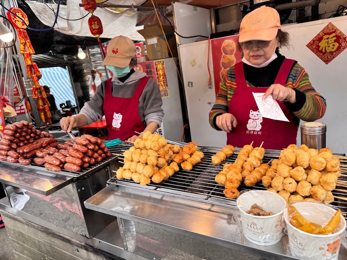 Taiwanese street-food vendors grilling sausages and fish balls